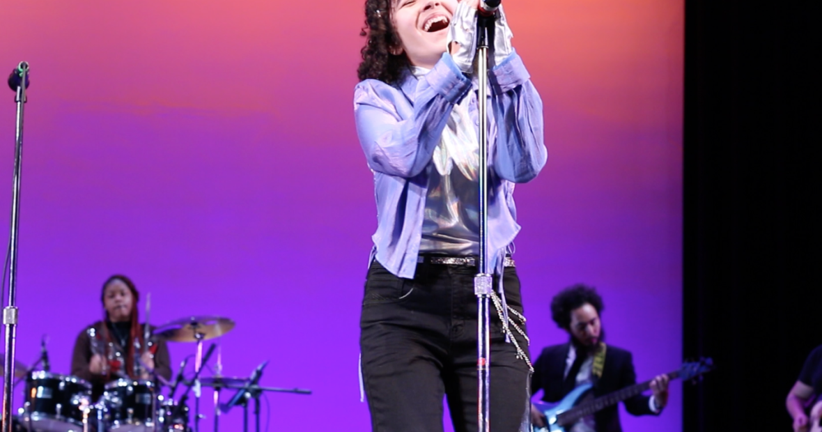 singer belting out front and center with base and percussion in the background
