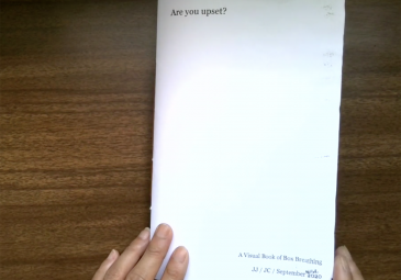 Hands opening a handmade book titled Are You Upset