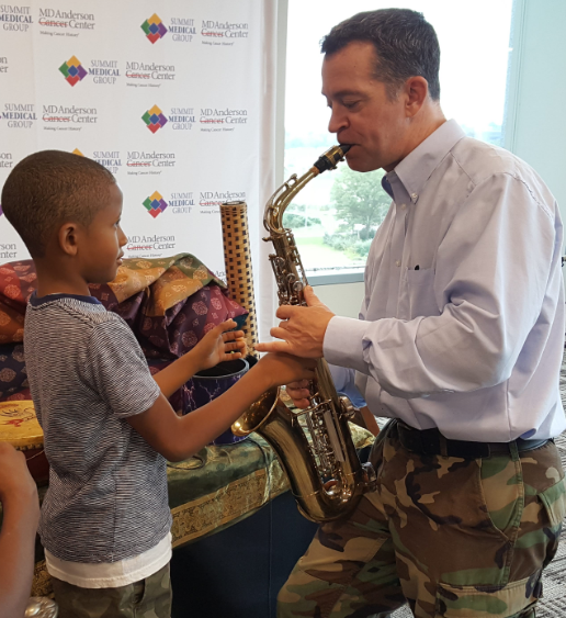 Man playing the saxophone with child