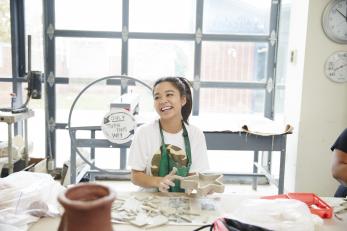 female student smiling in ceramics room