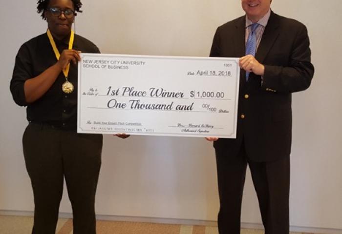 Raven Smith, freshman Management major at NJCU, is congratulated by NJCU School of Business Dean Dr. Bernard McSherry for winning the 2018 Build Your Dream Business Pitch Competition.