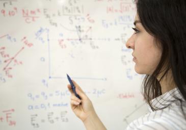 female student doing math on whiteboard