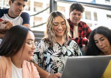 FIVE STUDENTS LOOK AT LAPTOP