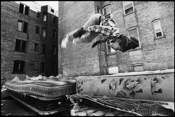 child jumps mattress in photograph